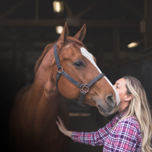 Lady hugging her horse.